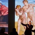 Professor Paul Crenshaw standing in front of a projection of several Rembrandt etchings during a 