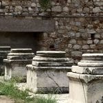 Student Nicole Jozwik examining a weathered stone altar during a study abroad trip to an archaeological site in Crete.