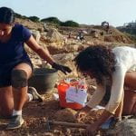 Students Charlotte and Norbert examining an ancient Roman trench at an archaeological site.