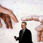 Professor Paul Crenshaw gesturing during an Art History lecture in front of a projection of Michelangelo's 